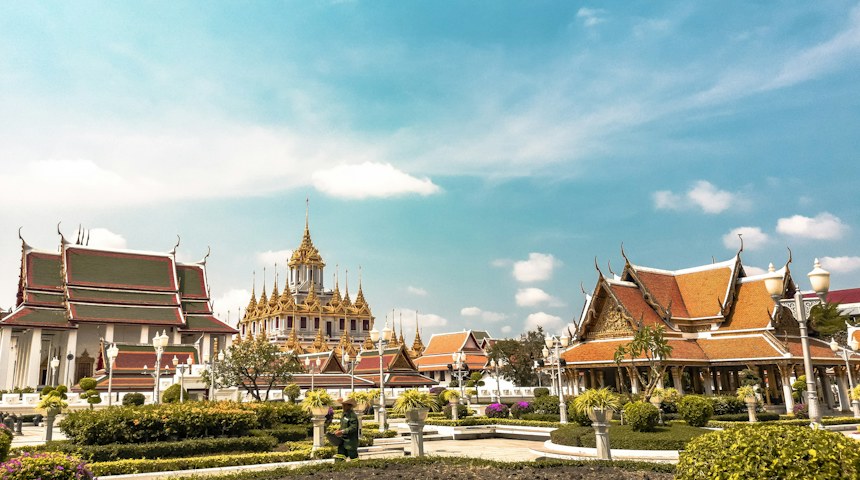 Orange and gold temple roofs in Bangkok on a sunny day
