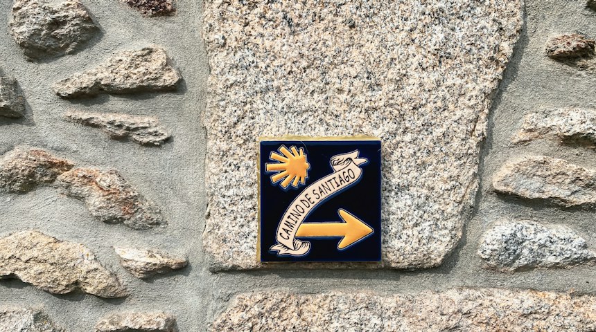 Camino de Santiago waymarker sign on a stone wall