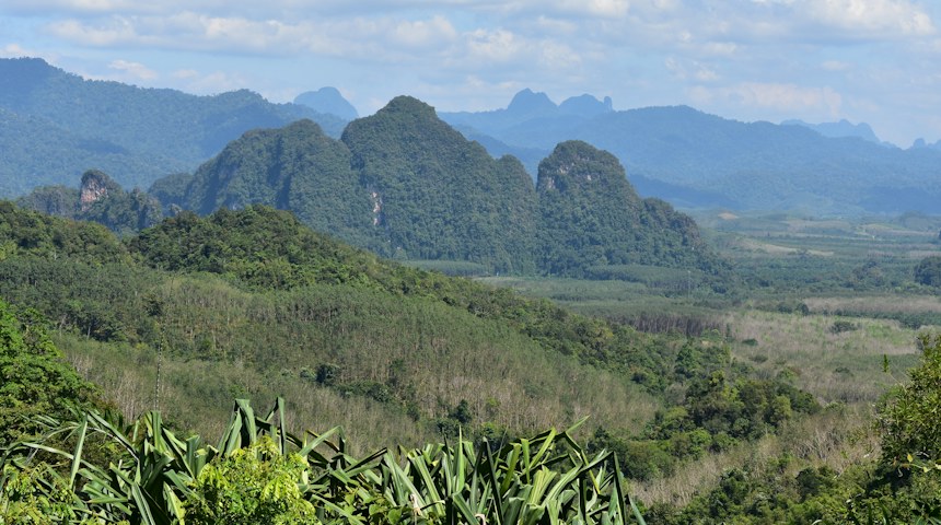 Lush green valley surrounded by forested hills near Chiang Mai