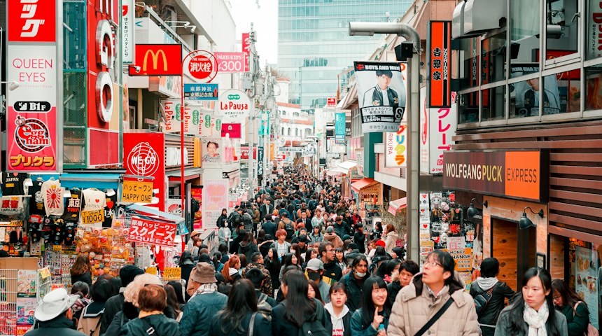 People walking along a busy shopping street in Harajuku, Tokyo