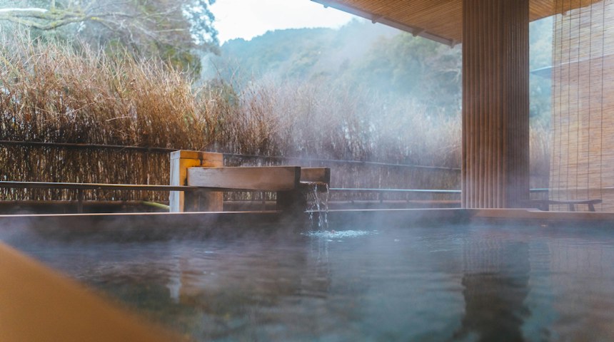 Outdoor onsen hot spring pool beside a traditional Japanese building