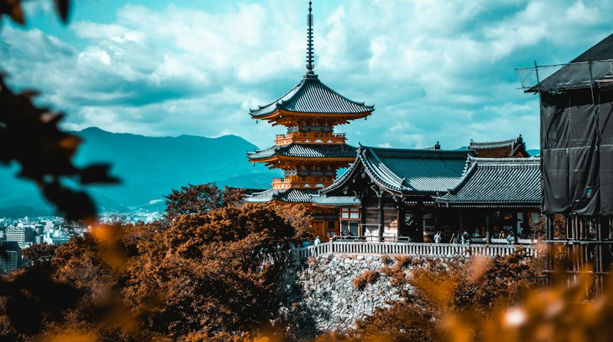 Traditional five-storey pagoda in Kyoto under a blue sky