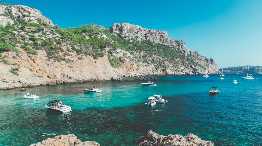 White and blue boat on clear sea off Mallorca