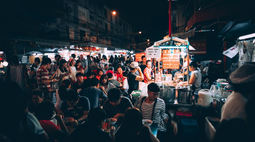 People eating at a street food stall in Thailand