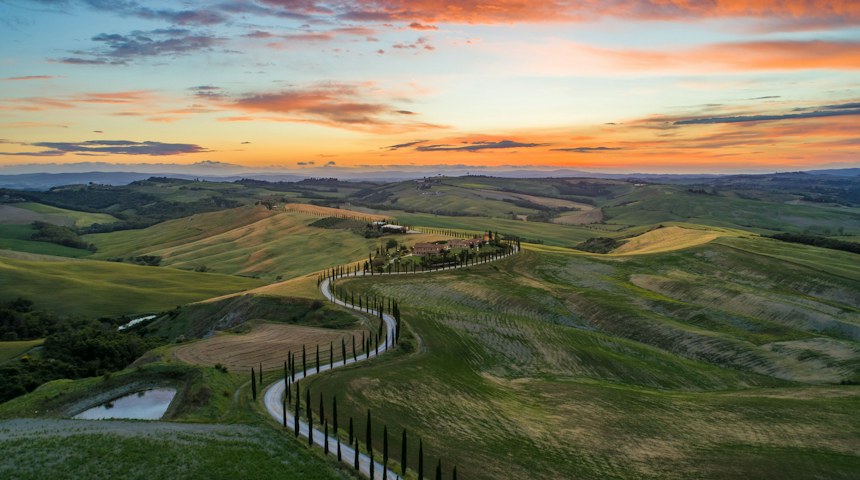 Winding road lined with cypress trees in Tuscany
